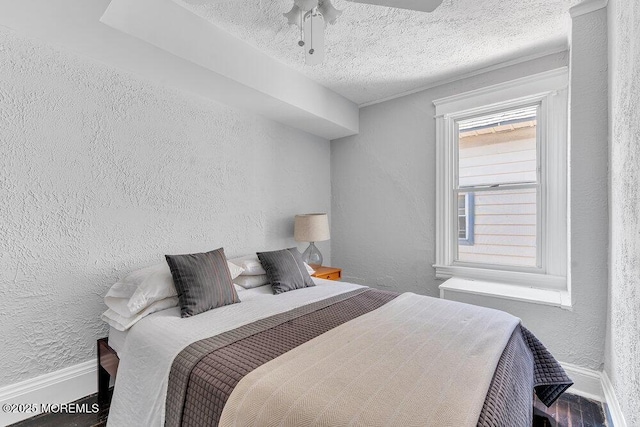 708 7th Ave, Asbury Park, NJ 07712 - bedroom featuring baseboards, a textured wall, wood finished floors, a textured ceiling, and ceiling fan