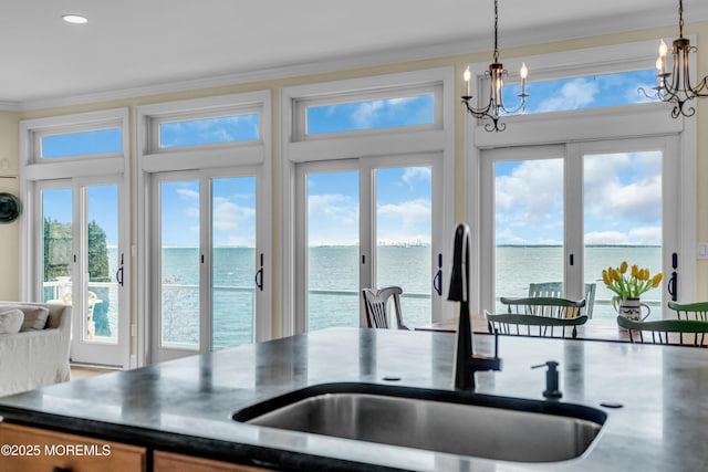 42 Bayside Dr, Atlantic Highlands, NJ 07716 - kitchen featuring a sink, a water view, a chandelier, ornamental molding, and plenty of natural light