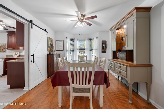 470 Nautilus Dr, Manahawkin, NJ 08050 - dining area featuring ceiling fan, a barn door, and light wood-style flooring