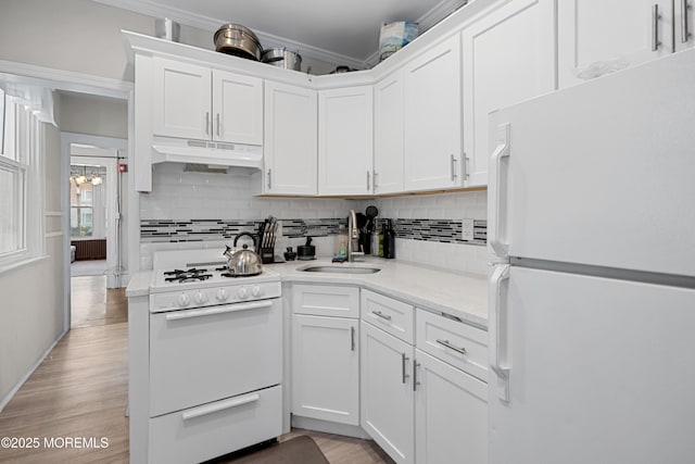 31 Riverside Ave, Red Bank, NJ 07701 - kitchen featuring white appliances, under cabinet range hood, a sink, crown molding, and white cabinets