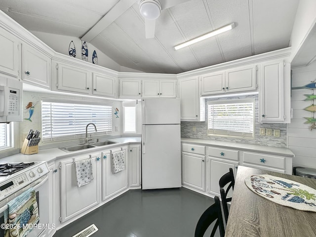 709 Union Ave Unit 5, Brielle, NJ 08730 - kitchen featuring white appliances, white cabinets, vaulted ceiling, light countertops, and backsplash