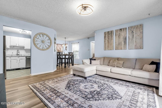 305 Daisy Ct, Jackson, NJ 08527 - living area with light wood-style flooring, a textured ceiling, a chandelier, and baseboards