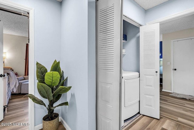 305 Daisy Ct, Jackson, NJ 08527 - washroom featuring washer / clothes dryer, light wood-style flooring, a textured ceiling, and baseboards