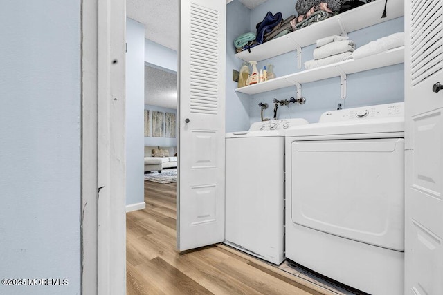 305 Daisy Ct, Jackson, NJ 08527 - laundry area featuring washer and dryer, light wood finished floors, and a textured ceiling