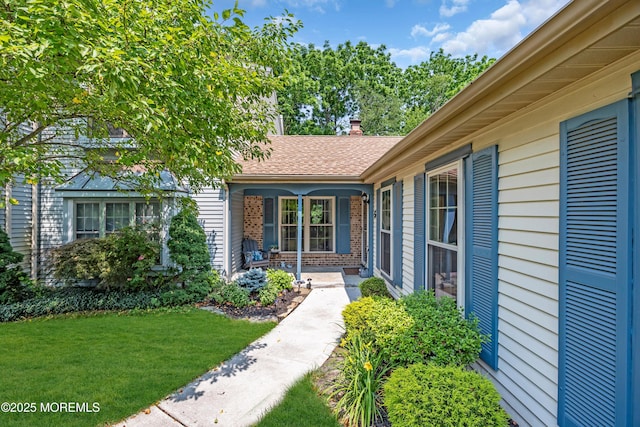 6 Claridge Ct # 5, Freehold, NJ 07728 - property entrance with a yard, covered porch, roof with shingles, and brick siding