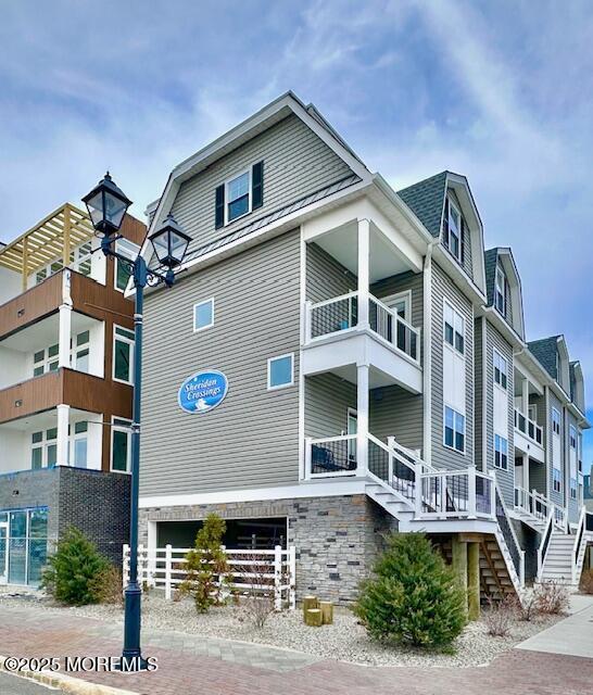 64 Sheridan Ave Unit A, Seaside Heights, NJ 08751 - view of side of home with stairs, a balcony, and a gambrel roof