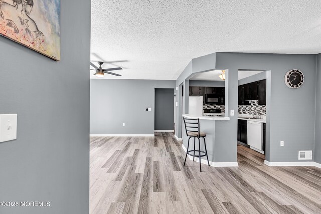 113 Whispering Oaks Way, Jackson, NJ 08527 - kitchen featuring white appliances, a breakfast bar area, light wood-style floors, light countertops, and a textured ceiling
