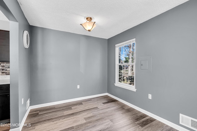 113 Whispering Oaks Way, Jackson, NJ 08527 - unfurnished dining area featuring a textured ceiling, wood finished floors, and baseboards