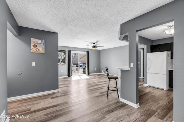 113 Whispering Oaks Way, Jackson, NJ 08527 - unfurnished living room with a textured ceiling, wood finished floors, ceiling fan, and baseboards