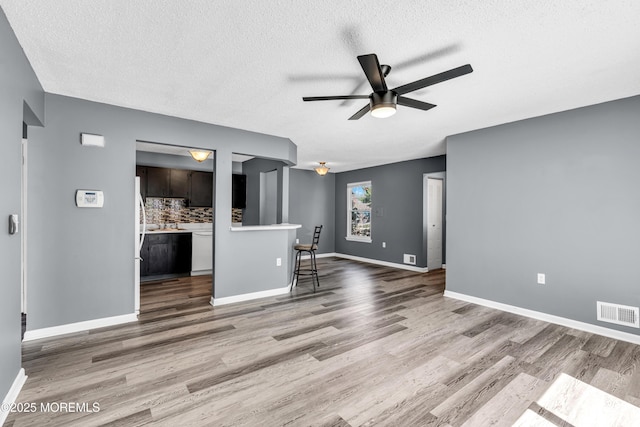 113 Whispering Oaks Way, Jackson, NJ 08527 - unfurnished living room with ceiling fan, wood finished floors, a textured ceiling, and baseboards