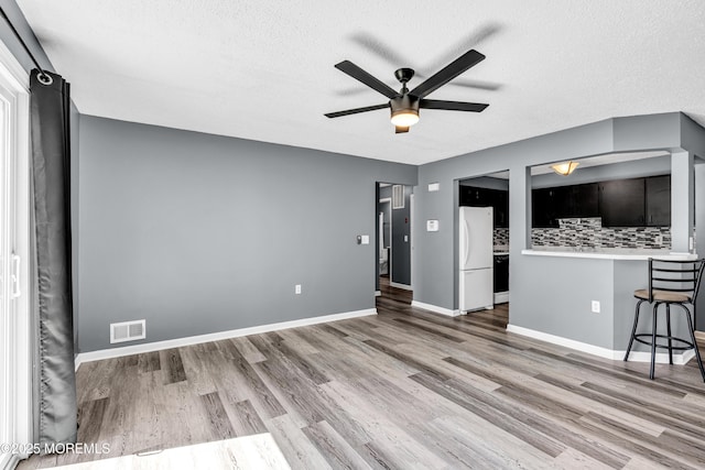113 Whispering Oaks Way, Jackson, NJ 08527 - unfurnished living room featuring ceiling fan, wood finished floors, a textured ceiling, and baseboards