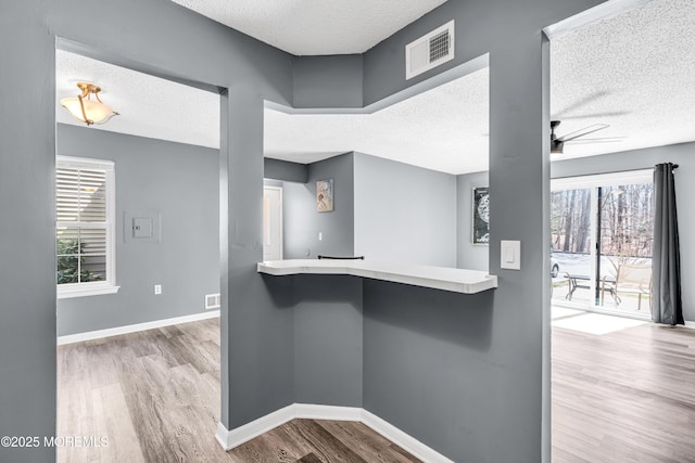 113 Whispering Oaks Way, Jackson, NJ 08527 - kitchen with a textured ceiling, wood finished floors, a ceiling fan, baseboards, and a breakfast bar area
