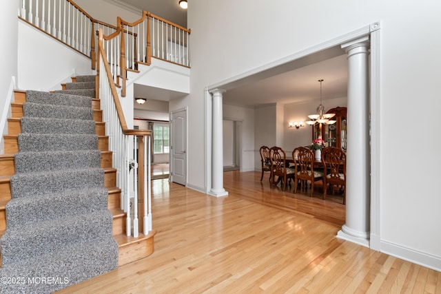 27 Witherspoon Way, Marlboro, NJ 07746 - stairway with decorative columns, wood finished floors, a chandelier, and baseboards