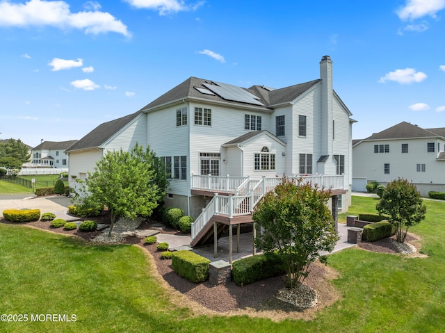 27 Witherspoon Way, Marlboro, NJ 07746 - back of house featuring solar panels, a lawn, stairway, a wooden deck, and a chimney