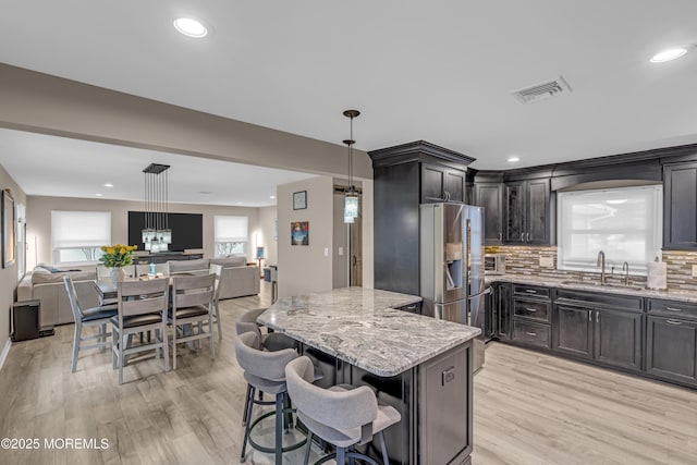 103 Idlewild Ln, Aberdeen, NJ 07747 - kitchen featuring open floor plan, a sink, light stone counters, light wood-type flooring, and backsplash