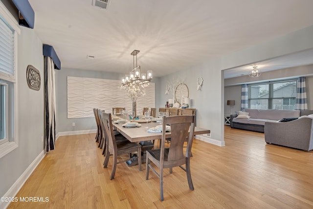 728 Brook Ave, Union Beach, NJ 07735 - dining area with a chandelier, light wood-style flooring, and baseboards