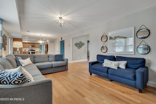 728 Brook Ave, Union Beach, NJ 07735 - living room with light wood-type flooring, baseboards, and a chandelier