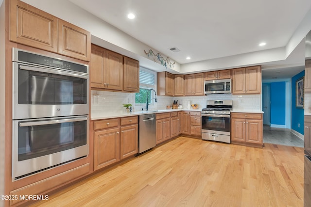 728 Brook Ave, Union Beach, NJ 07735 - kitchen with appliances with stainless steel finishes, light countertops, light wood-style floors, a sink, and decorative backsplash