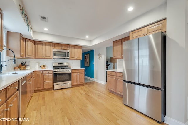 728 Brook Ave, Union Beach, NJ 07735 - kitchen with appliances with stainless steel finishes, a sink, baseboards, decorative backsplash, and light wood-type flooring