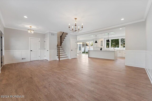 1119 Northstream Pkwy, Point Pleasant, NJ 08742 - unfurnished living room with a chandelier, stairs, ornamental molding, light wood finished floors, and a wainscoted wall