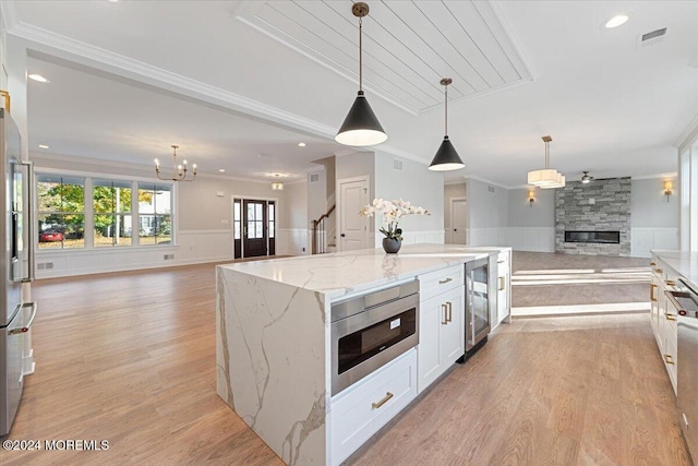 1119 Northstream Pkwy, Point Pleasant, NJ 08742 - kitchen with open floor plan, appliances with stainless steel finishes, crown molding, a fireplace, and a chandelier
