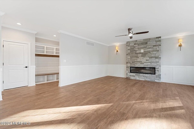 1119 Northstream Pkwy, Point Pleasant, NJ 08742 - unfurnished living room with ceiling fan, wood finished floors, a fireplace, crown molding, and a wainscoted wall