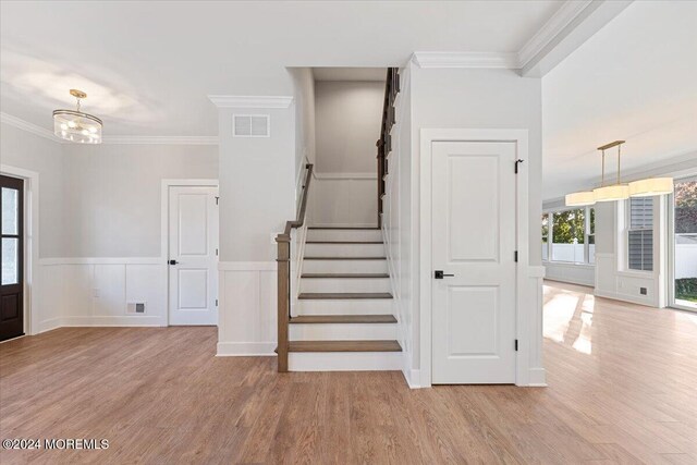 1119 Northstream Pkwy, Point Pleasant, NJ 08742 - stairway featuring wood finished floors, wainscoting, crown molding, and a chandelier