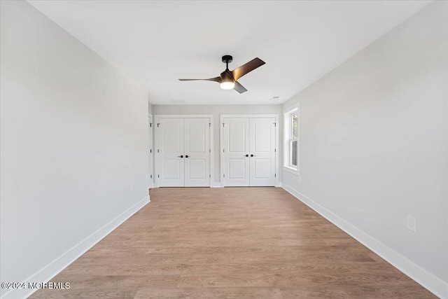 1119 Northstream Pkwy, Point Pleasant, NJ 08742 - unfurnished bedroom featuring two closets, baseboards, wood finished floors, and a ceiling fan