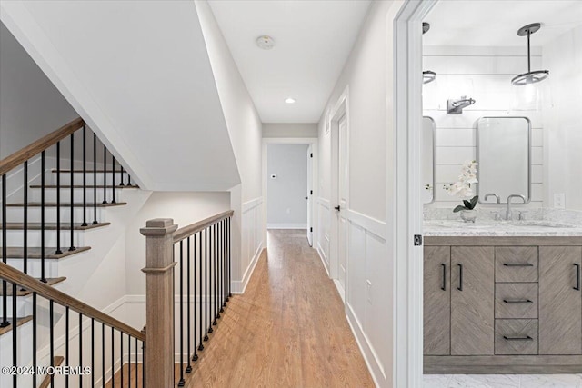 1119 Northstream Pkwy, Point Pleasant, NJ 08742 - hallway with a sink, light wood finished floors, baseboards, and stairway