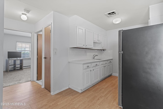 1036A Aberdeen Dr, Lakewood, NJ 08701 - kitchen with freestanding refrigerator, light countertops, light wood-style floors, and white cabinets