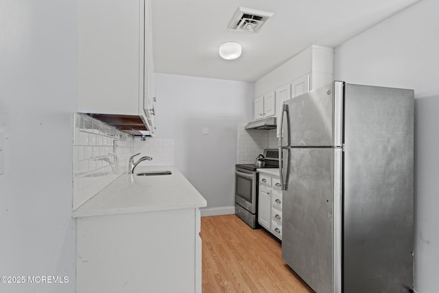 1036A Aberdeen Dr, Lakewood, NJ 08701 - kitchen featuring appliances with stainless steel finishes, under cabinet range hood, light countertops, light wood-style floors, and decorative backsplash