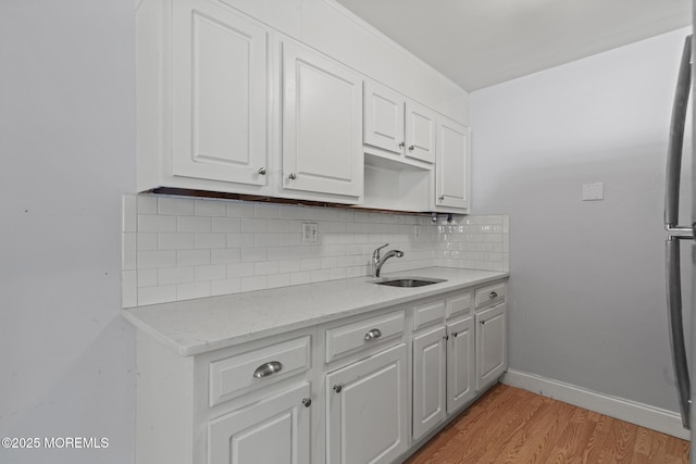 1036A Aberdeen Dr, Lakewood, NJ 08701 - kitchen featuring tasteful backsplash, white cabinets, light wood-style floors, and light stone counters