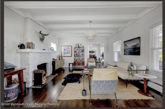 1 S Ocean Ave, Loch Arbour, NJ 07711 - living area featuring wood finished floors, plenty of natural light, beam ceiling, and a fireplace