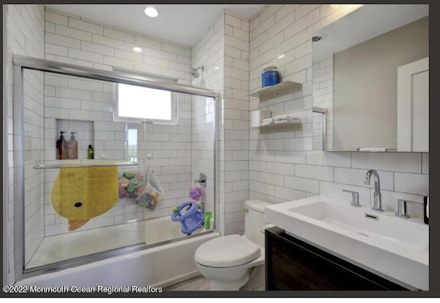 1 S Ocean Ave, Loch Arbour, NJ 07711 - full bath with shower / bath combination with glass door, tile walls, vanity, toilet, and tasteful backsplash
