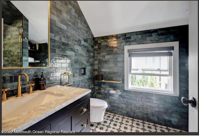 1 S Ocean Ave, Loch Arbour, NJ 07711 - bathroom with vaulted ceiling, vanity, toilet, and tile walls