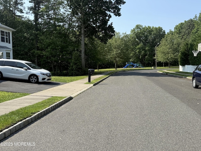 44 Diamond Ln, Howell, NJ 07731 - view of asphalt road featuring street lighting, curbs, sidewalks, and view of scattered trees