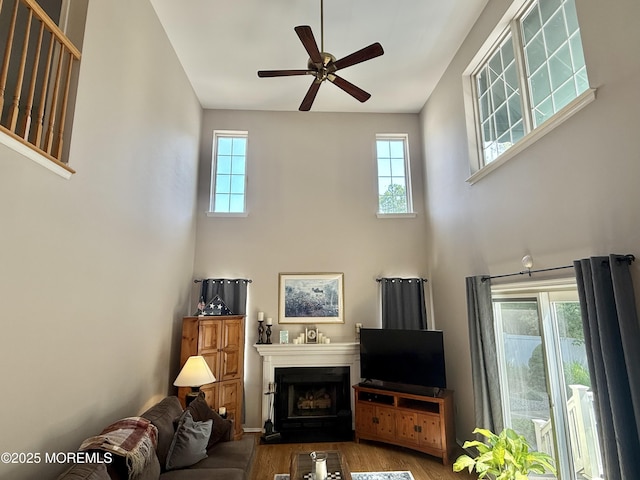 44 Diamond Ln, Howell, NJ 07731 - living room with healthy amount of natural light, a high ceiling, wood finished floors, ceiling fan, and a fireplace with flush hearth