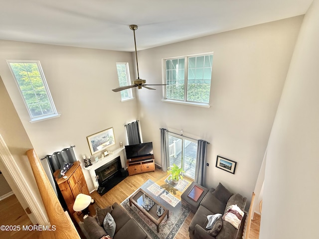 44 Diamond Ln, Howell, NJ 07731 - living area with plenty of natural light, a towering ceiling, light wood-style flooring, a ceiling fan, and a fireplace with flush hearth