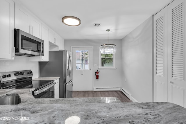 9 Edinburgh Ln Unit D, Manchester, NJ 08759 - kitchen featuring appliances with stainless steel finishes, wood finished floors, a baseboard radiator, white cabinetry, and light stone countertops