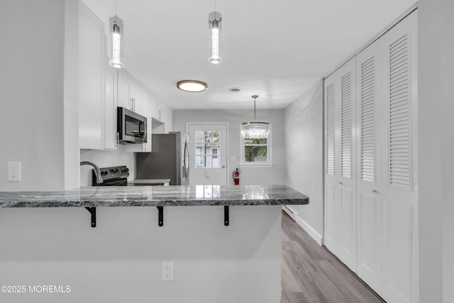 9 Edinburgh Ln Unit D, Manchester, NJ 08759 - kitchen featuring appliances with stainless steel finishes, a kitchen breakfast bar, white cabinetry, and a peninsula