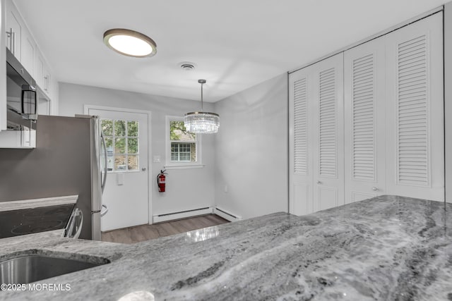 9 Edinburgh Ln Unit D, Manchester, NJ 08759 - unfurnished dining area with a baseboard heating unit, wood finished floors, and a chandelier