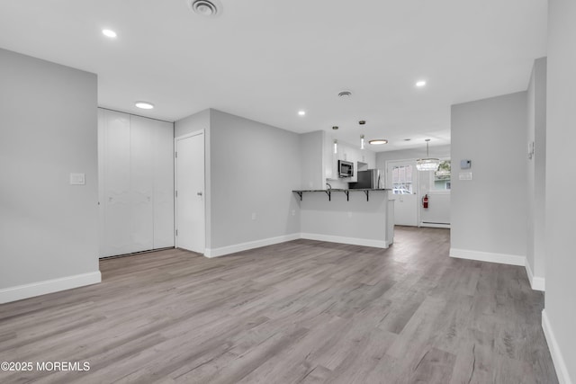 9 Edinburgh Ln Unit D, Manchester, NJ 08759 - unfurnished living room with light wood-style floors, baseboards, baseboard heating, and recessed lighting