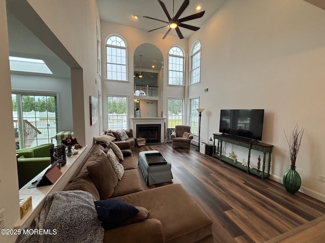 10 English Path, Freehold, NJ 07728 - living room featuring ceiling fan, a towering ceiling, dark wood-type flooring, a fireplace, and baseboards