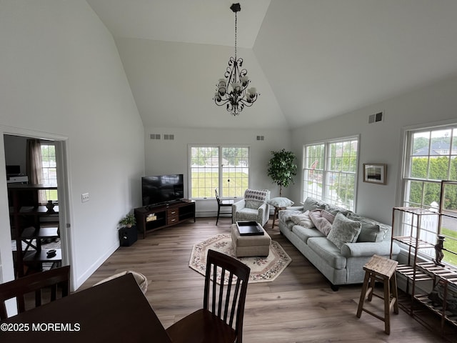 10 English Path, Freehold, NJ 07728 - living room with high vaulted ceiling, a chandelier, plenty of natural light, and wood finished floors