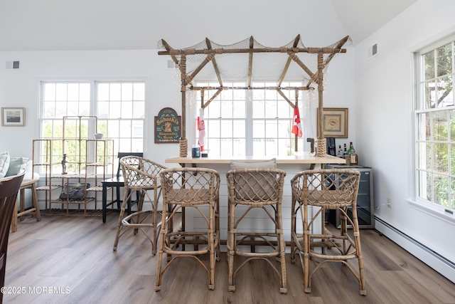 10 English Path, Freehold, NJ 07728 - dining space with a baseboard radiator, lofted ceiling, wood finished floors, and healthy amount of natural light