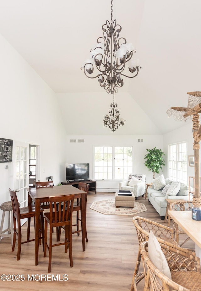 10 English Path, Freehold, NJ 07728 - dining space with a chandelier, high vaulted ceiling, light wood-style floors, and healthy amount of natural light