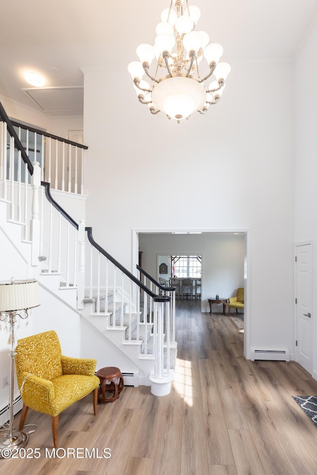 10 English Path, Freehold, NJ 07728 - entrance foyer with a baseboard radiator, a high ceiling, wood finished floors, stairs, and a chandelier
