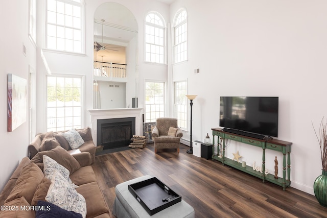 10 English Path, Freehold, NJ 07728 - living room featuring a high ceiling, ceiling fan, dark wood-type flooring, a fireplace with flush hearth, and a baseboard radiator