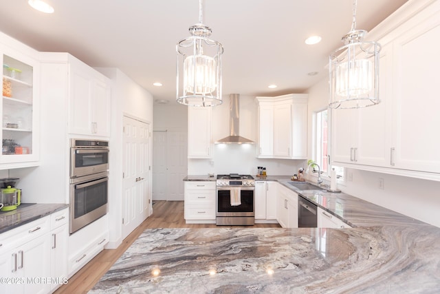 10 English Path, Freehold, NJ 07728 - kitchen featuring appliances with stainless steel finishes, wall chimney range hood, stone countertops, white cabinetry, and a chandelier
