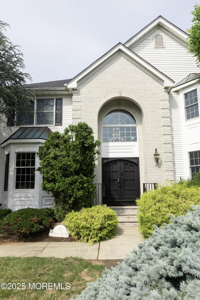 10 English Path, Freehold, NJ 07728 - view of front of property featuring brick siding, a standing seam roof, and a metal roof
